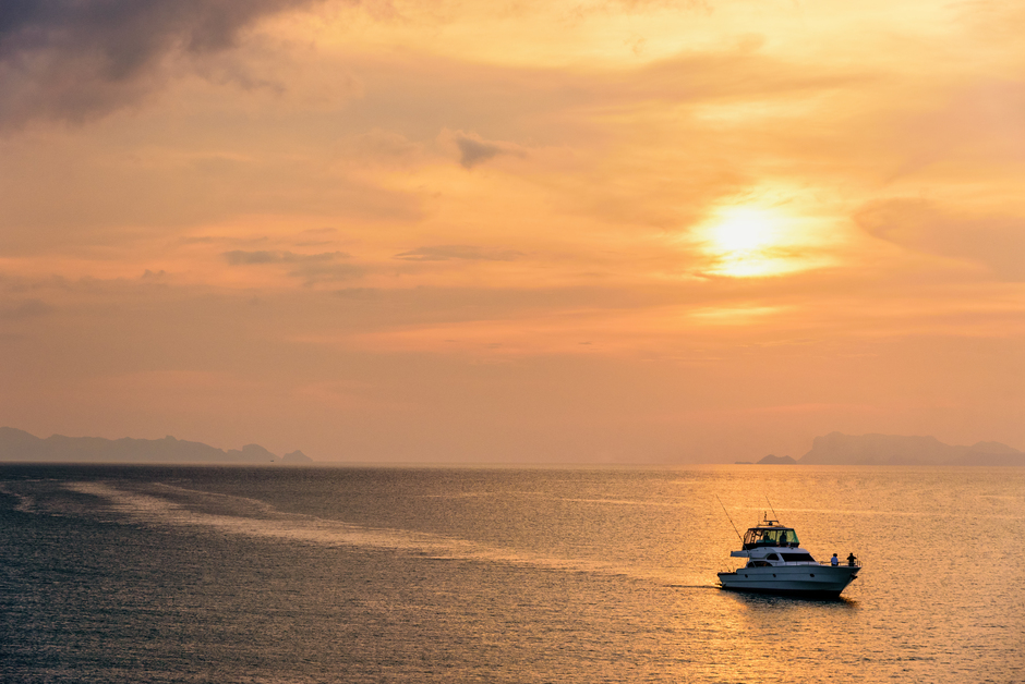 Barca a motore a noleggio che naviga al tramonto