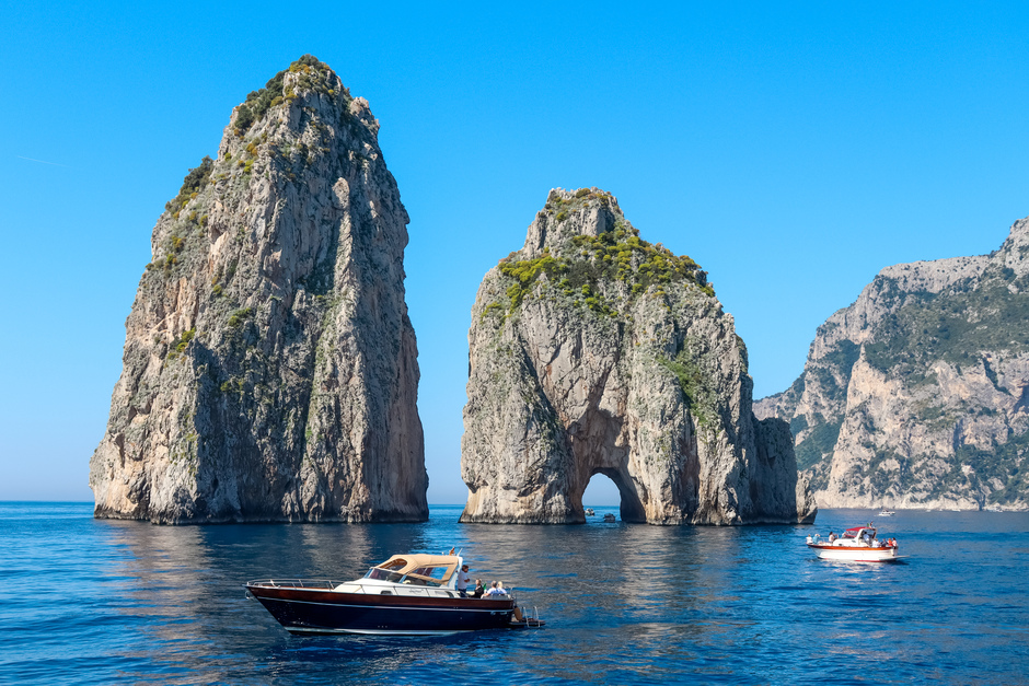 vista sui faraglioni di capri e barca a motore a noleggio
