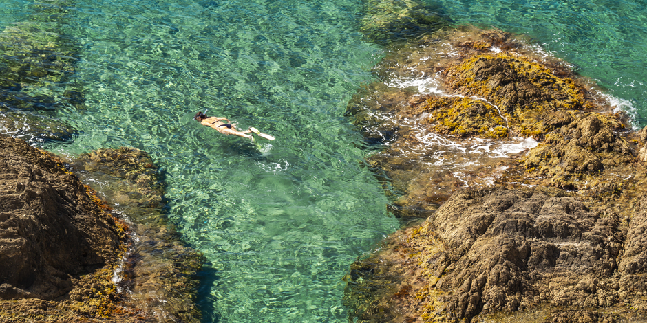 persona che fa snorkeling in acque cristalline