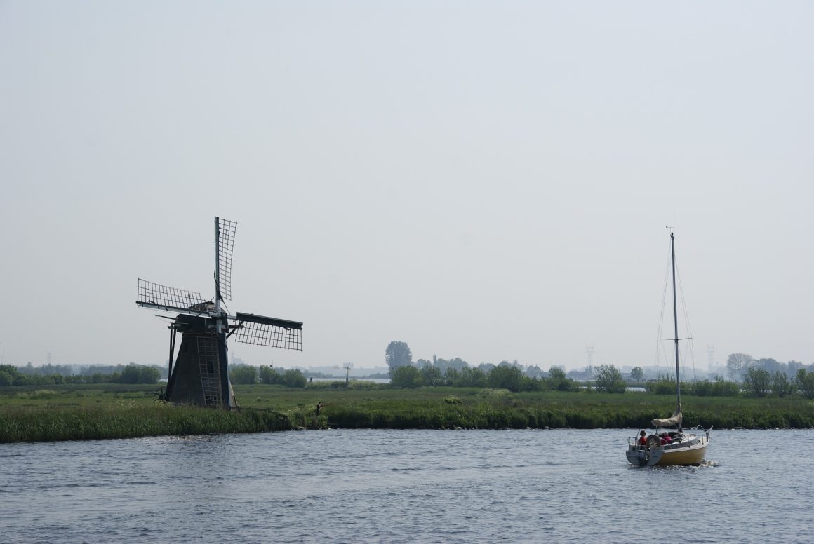 Zeilboot op kanaal met windmolen