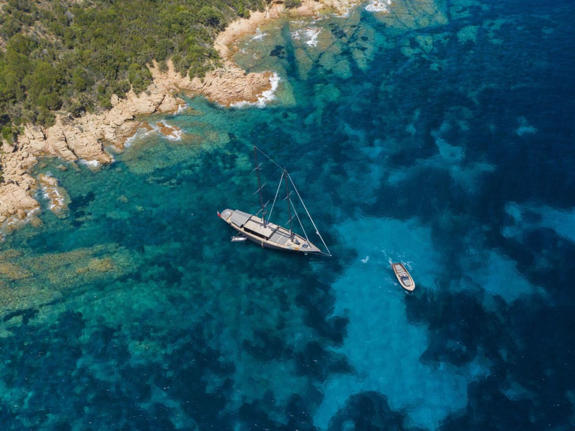 Bovenaanzicht van luxe zeilboot, drijvend op prachtige turquoise zee in Sardinië, Italië 
Ideale leuke vakantie bestemming.