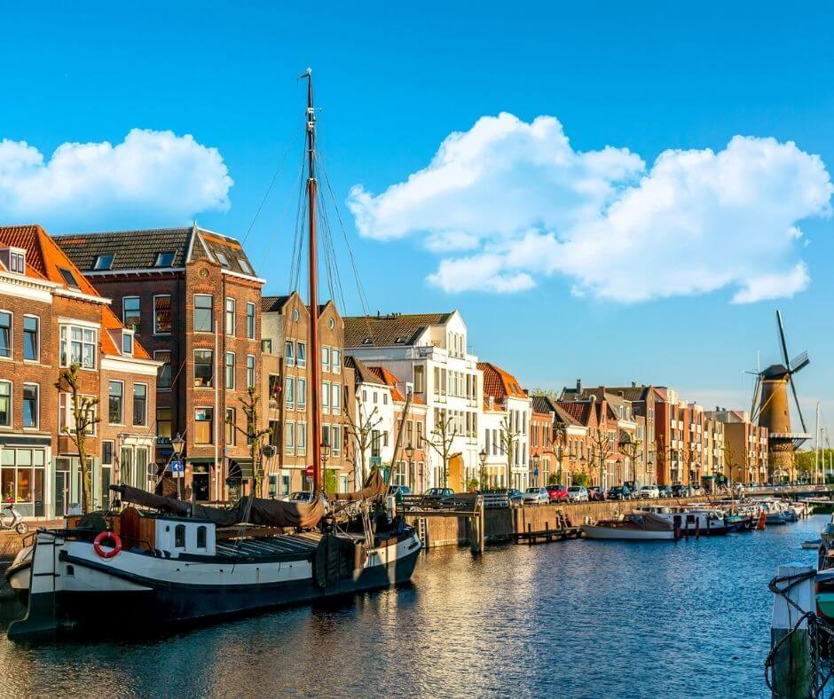 Oude historische wijk Delfshaven met molen en woonboten in Rotterdam, Zuid-Holland, Nederland. Zomerse zonnige dag