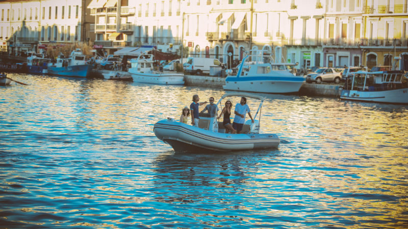 RIB on the Water, busy city street bordering the bank of the waterway in background