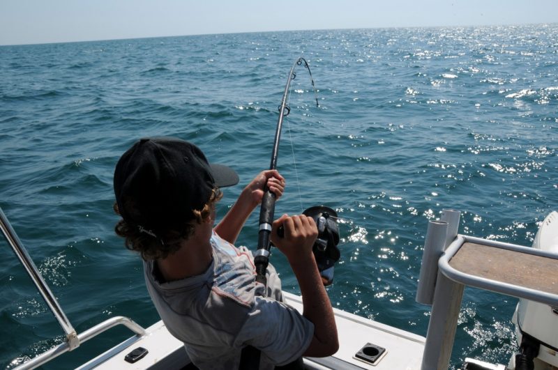 Young child fishing off a boat