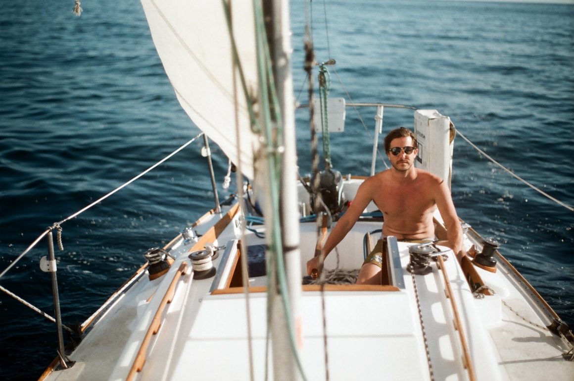 Man navigating a sailboat
