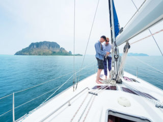Two boaters on sailboat in boating destination