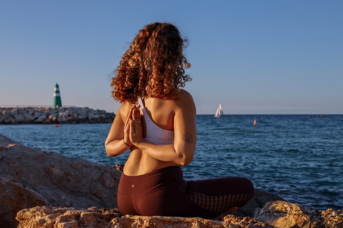 Woman doing yoga on the shore