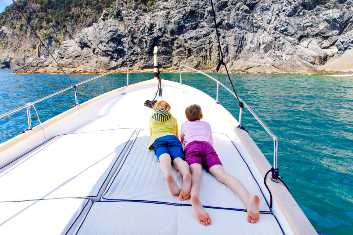 Two kids on the deck of a catamaran