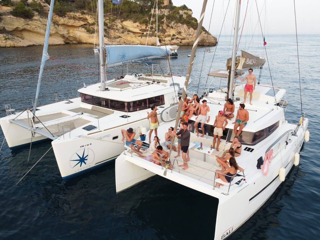 a group of people on two catamarans
