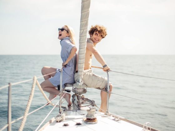 young couple sitting on the bow of a boat