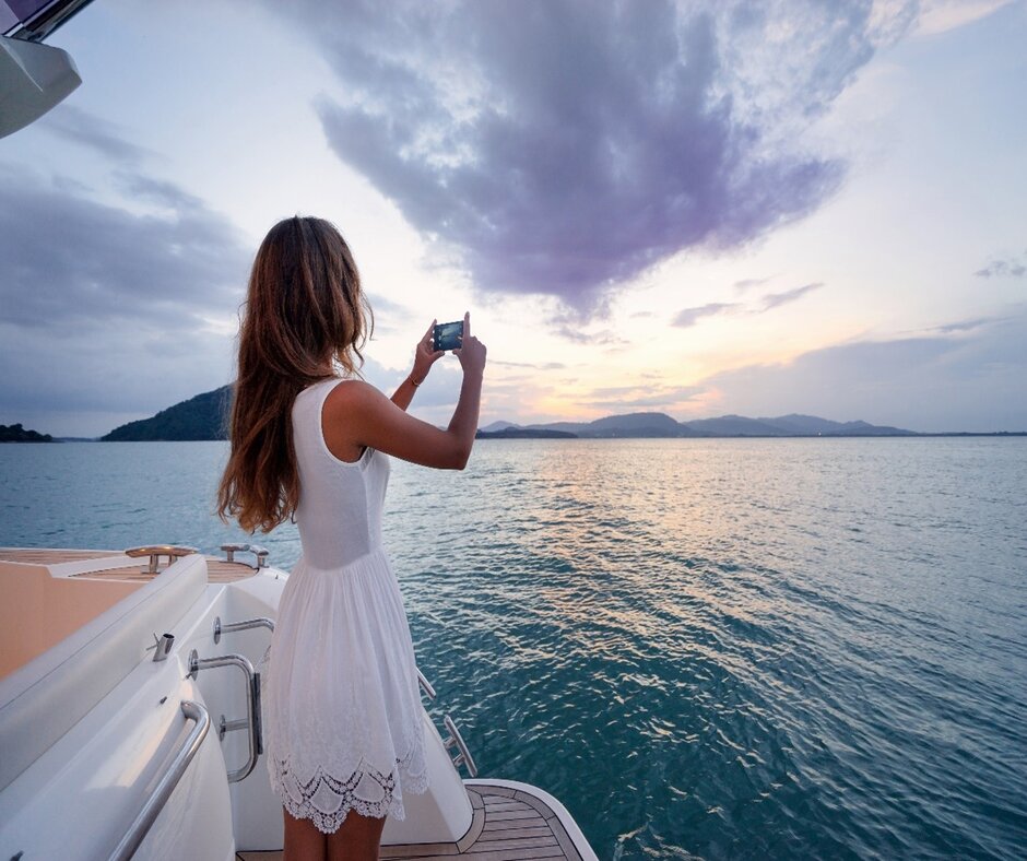 A woman capturing a sunset with her camera 