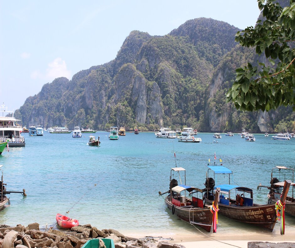Photo of a bay in Phuket, where many different styles of boats sit
