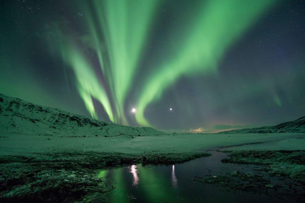 The northern lights over a snowy landscape in Iceland