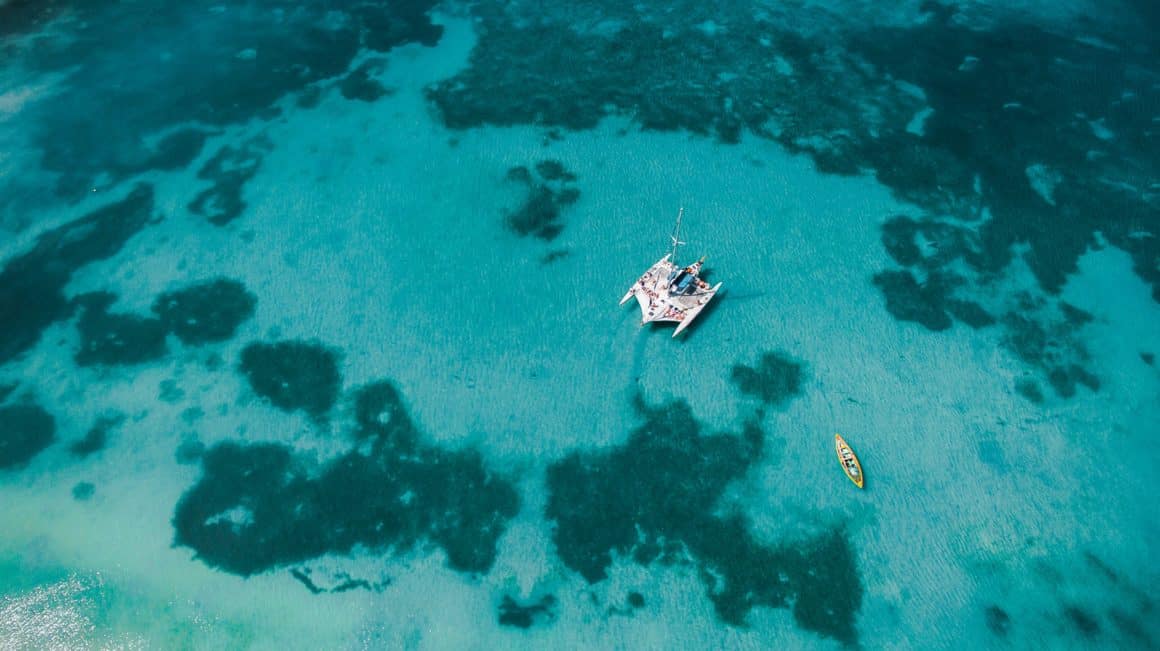 Un catamaran et un kayak mouillant dans un lagon
