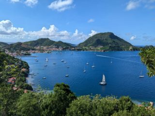 Vue aérienne de la baie des Saintes en Guadeloupe avec de nombreux voiliers au mouillage.