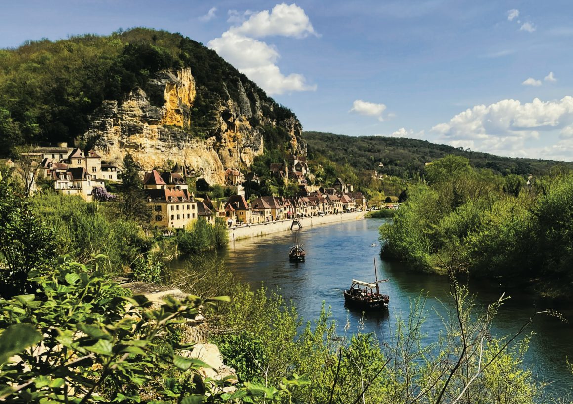 Gabares traditionnelles naviguant sur la Dordogne devant le village de La Roque-Gageac.