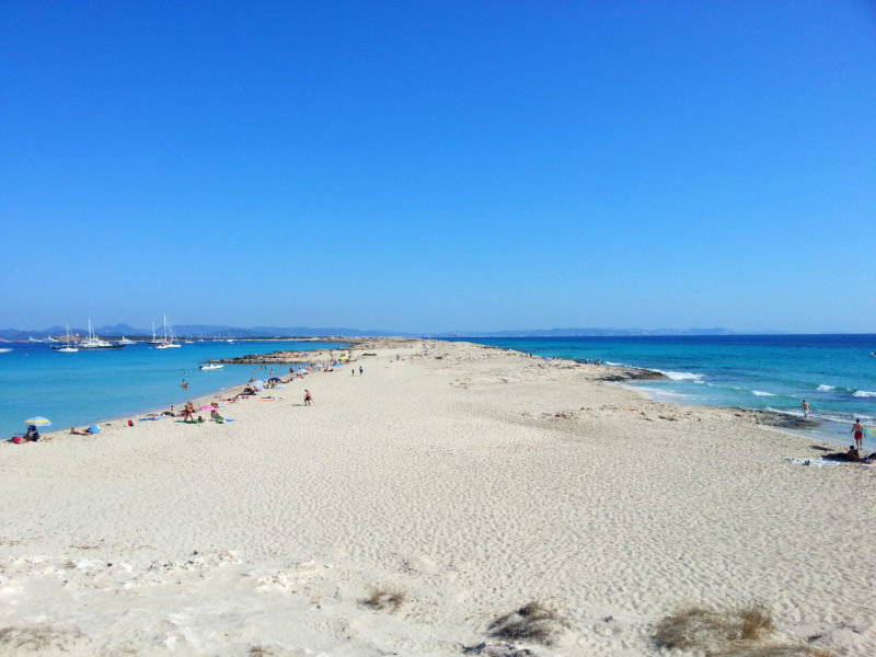 Banc de sable de Ses Illetes avec lagon bleu et plage animée.