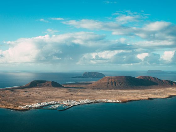 Vue aérienne de La Graciosa, île volcanique au nord de Lanzarote, avec village blanc et marina.